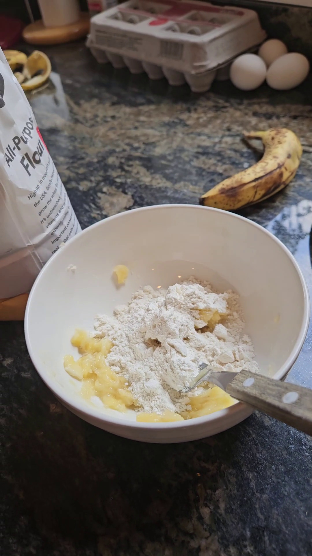 Adding flour to mashed banana and egg.